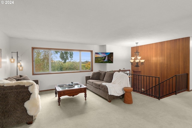 living room with a notable chandelier, wood walls, and carpet