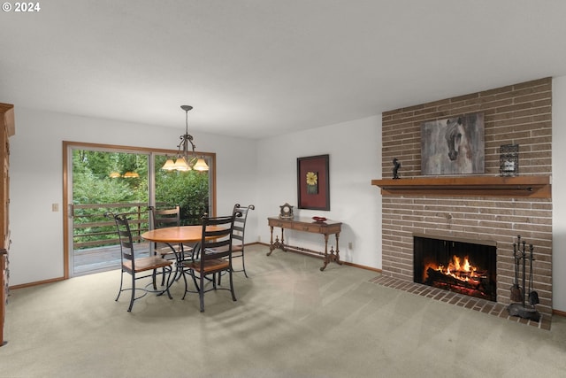 carpeted dining room featuring a brick fireplace and an inviting chandelier