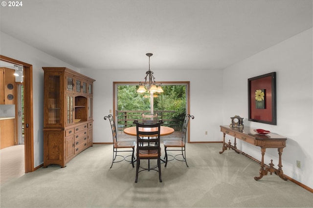 carpeted dining room featuring a notable chandelier