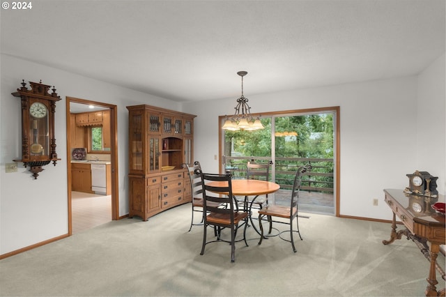 dining area with an inviting chandelier and light colored carpet