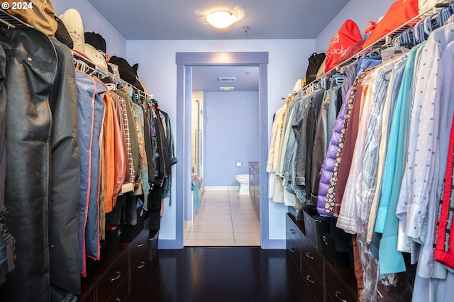 spacious closet with dark tile patterned floors