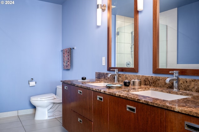 bathroom with toilet, vanity, tile patterned floors, and a shower with door