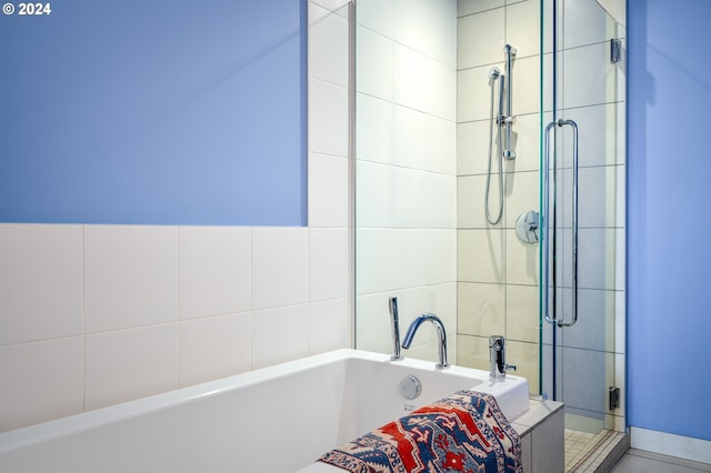 bathroom featuring shower with separate bathtub