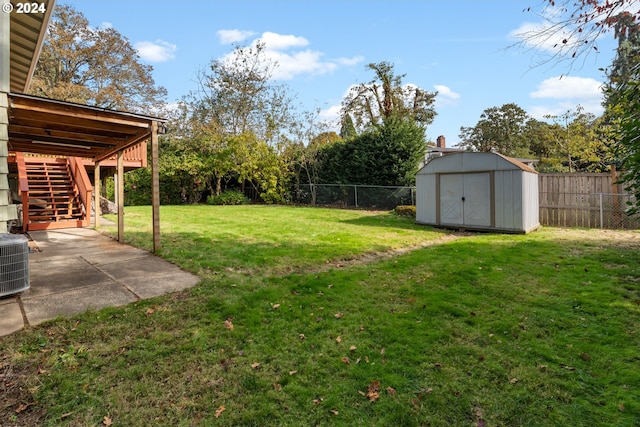 view of yard featuring a patio, central AC, and a shed