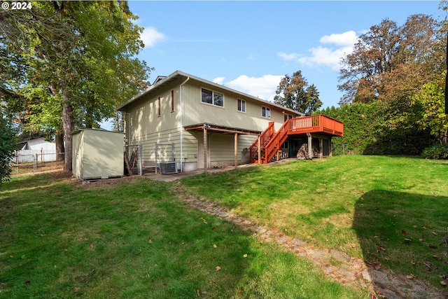 rear view of house with a yard, a wooden deck, and central air condition unit