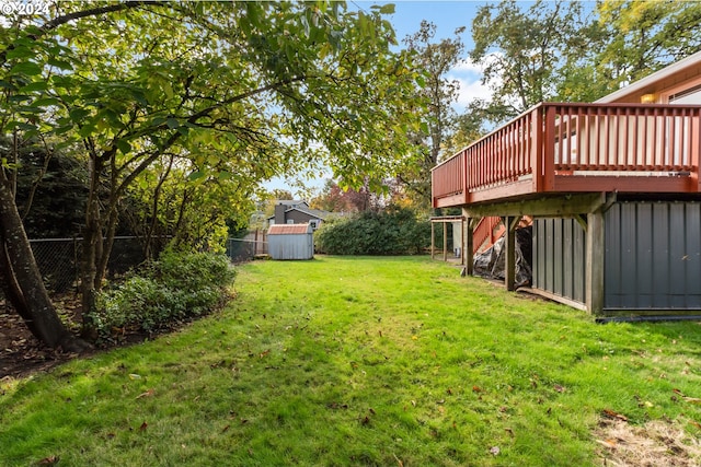 view of yard featuring a storage unit and a wooden deck