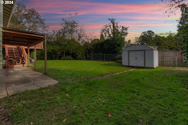 yard at dusk with a storage shed and a patio area