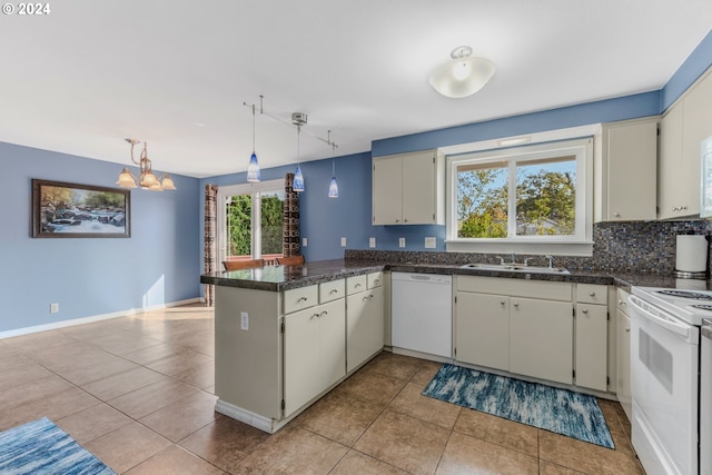 kitchen with kitchen peninsula, backsplash, sink, decorative light fixtures, and white appliances