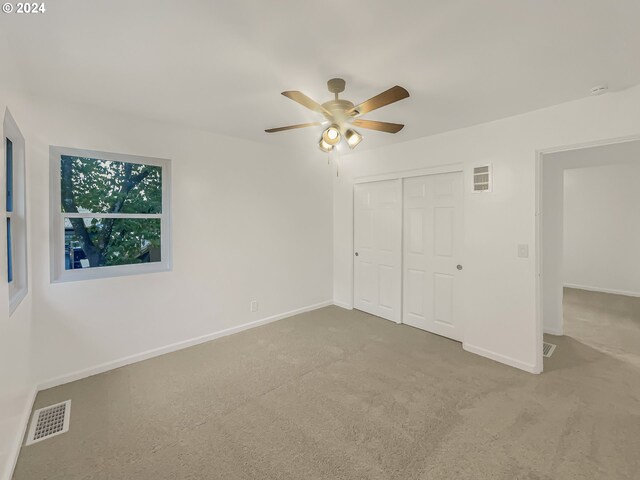 unfurnished bedroom featuring carpet, a closet, and ceiling fan