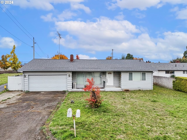 ranch-style home featuring aphalt driveway, a front yard, and fence