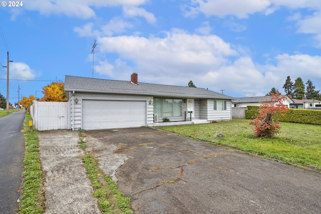 ranch-style house with a garage, fence, driveway, a chimney, and a front yard