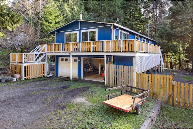 back of property featuring a deck and a garage