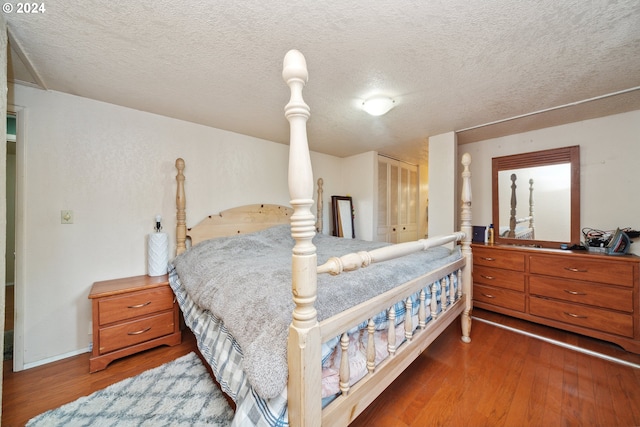 bedroom featuring dark hardwood / wood-style flooring, a closet, and a textured ceiling