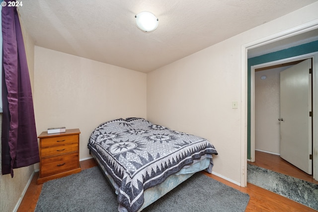 bedroom featuring a textured ceiling and wood-type flooring