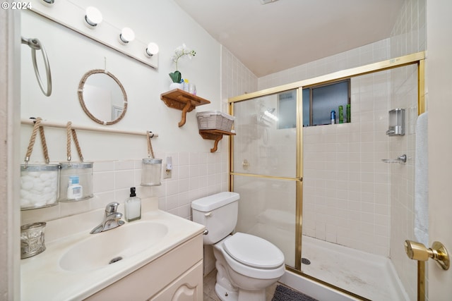 bathroom with toilet, backsplash, a shower with shower door, vanity, and tile walls