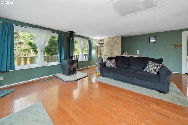 living room with a wood stove and hardwood / wood-style floors