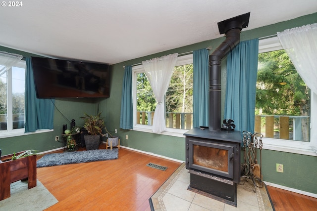 living room with a wood stove and light wood-type flooring