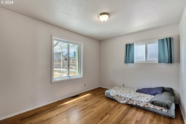 interior space with a textured ceiling and wood-type flooring