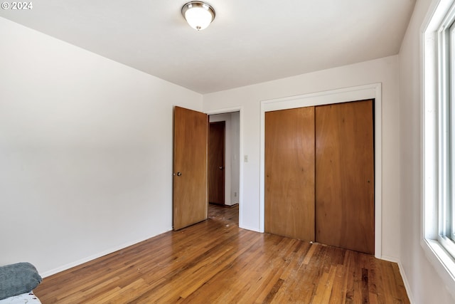 unfurnished bedroom with wood-type flooring and a closet