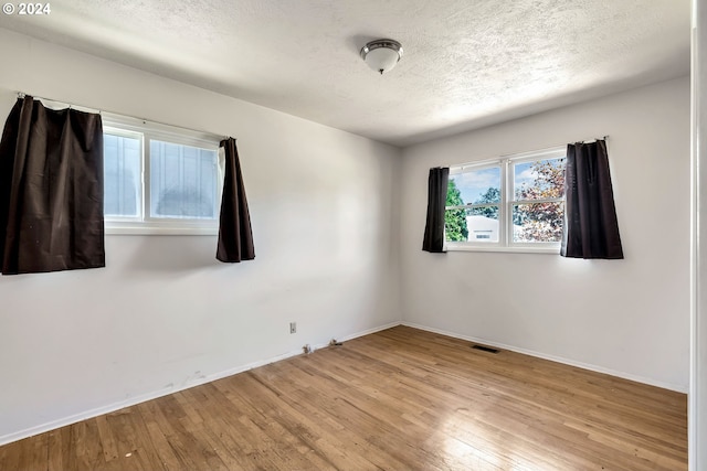 empty room featuring hardwood / wood-style floors and a textured ceiling