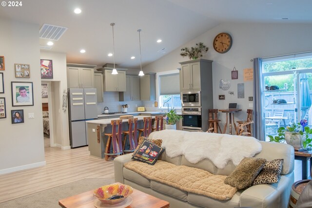 living room featuring light hardwood / wood-style floors and vaulted ceiling