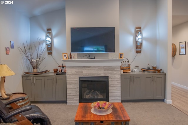 living room featuring light carpet and a tile fireplace