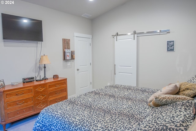 bedroom with a barn door and visible vents