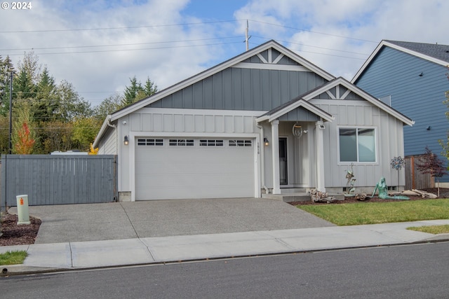 view of front of home featuring concrete driveway, an attached garage, fence, and board and batten siding