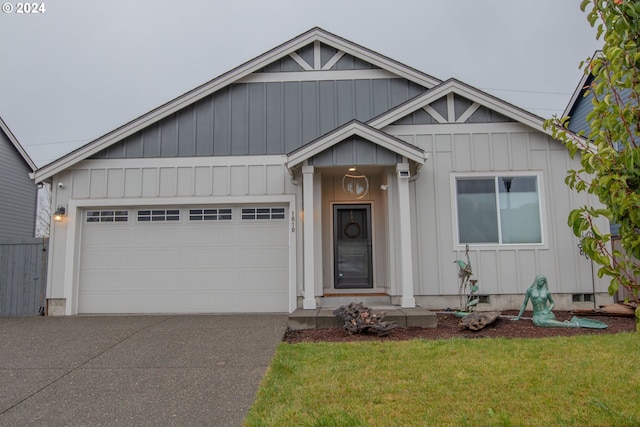 view of front of home featuring a front lawn, an attached garage, board and batten siding, and driveway