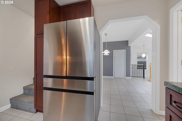 kitchen featuring pendant lighting, light tile patterned floors, and stainless steel refrigerator