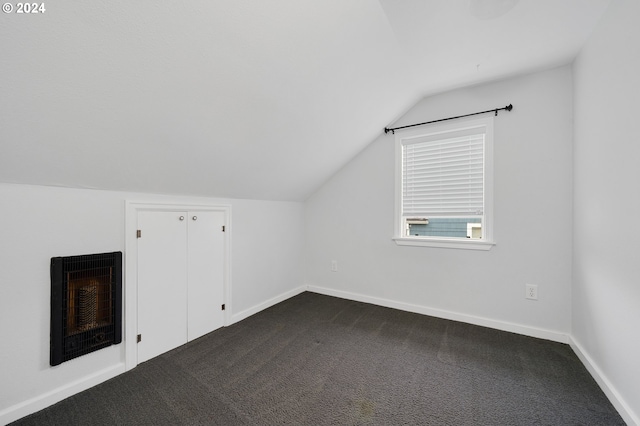 additional living space with heating unit, carpet, and vaulted ceiling