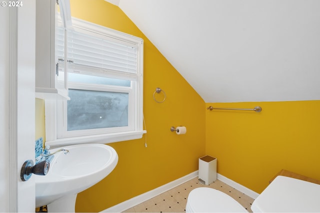 bathroom with sink, toilet, and lofted ceiling