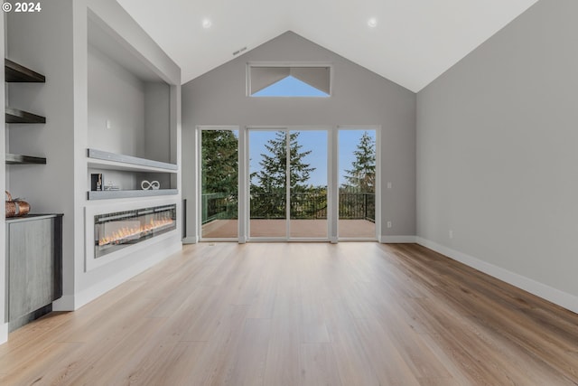 unfurnished living room featuring high vaulted ceiling and light hardwood / wood-style floors