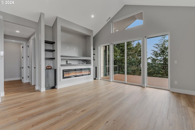 unfurnished living room featuring built in shelves, high vaulted ceiling, and light hardwood / wood-style flooring