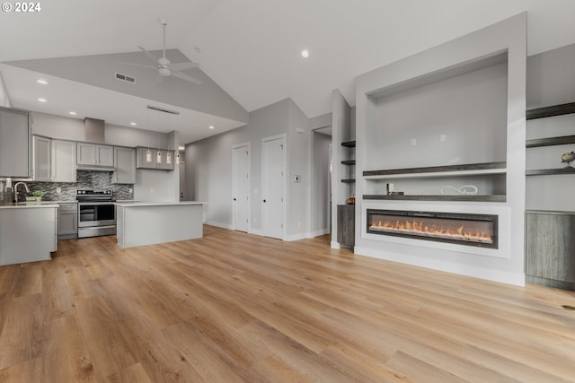 kitchen featuring light wood-type flooring, gray cabinetry, electric stove, high vaulted ceiling, and hanging light fixtures