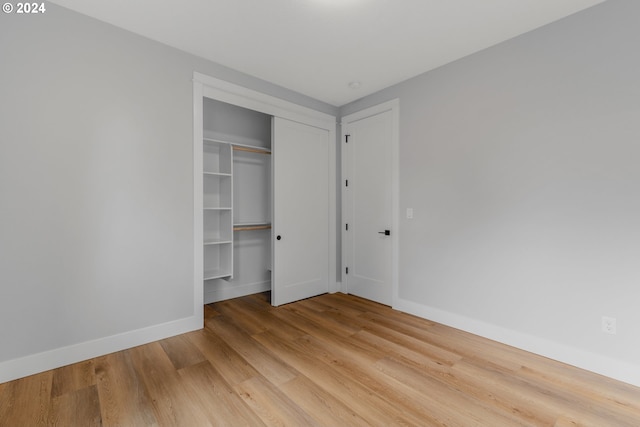 unfurnished bedroom with light hardwood / wood-style floors and a closet