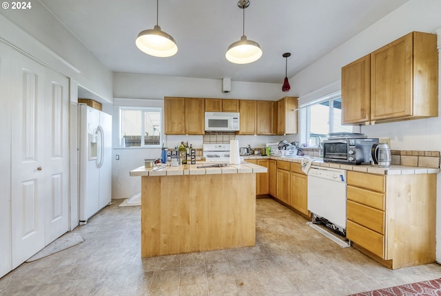 kitchen with white appliances, a center island, hanging light fixtures, and a healthy amount of sunlight