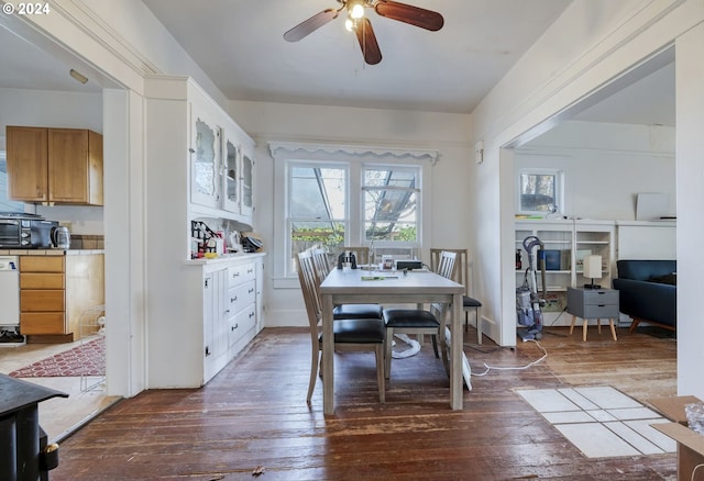 dining room with ceiling fan and dark wood-type flooring