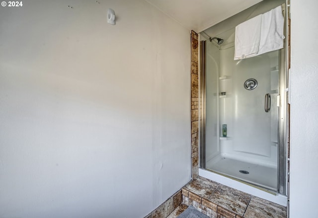 bathroom with a shower with door