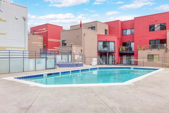 view of swimming pool featuring a patio area and a hot tub