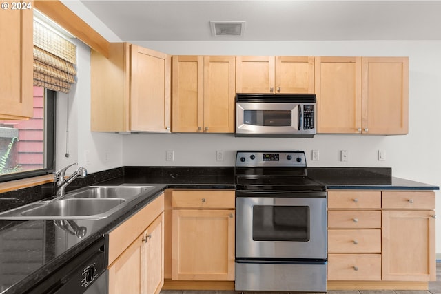 kitchen with light brown cabinetry, sink, and stainless steel appliances