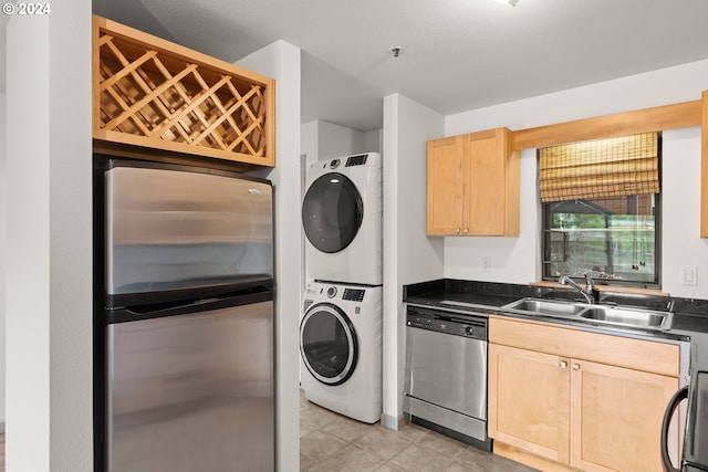 laundry room featuring sink, stacked washer / dryer, and light tile floors