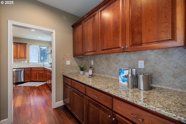 5310 NW Primino Ave, Portland, OR 97229 - kitchen featuring brown cabinets, stainless steel dishwasher, light stone countertops, and dark wood-type flooring