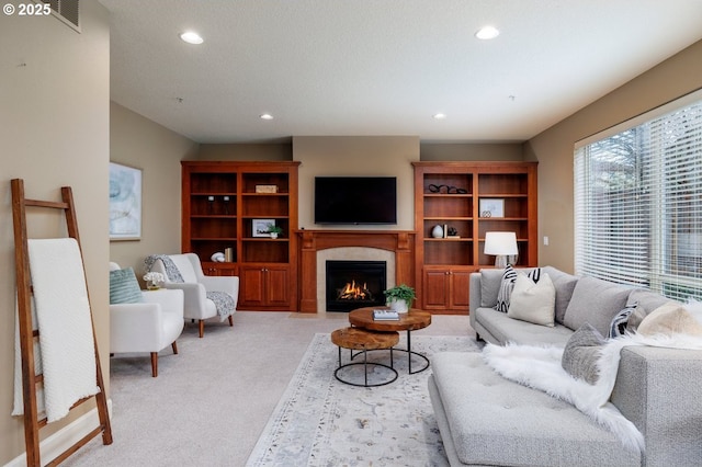 5310 NW Primino Ave, Portland, OR 97229 - living area featuring light carpet, visible vents, recessed lighting, and a warm lit fireplace