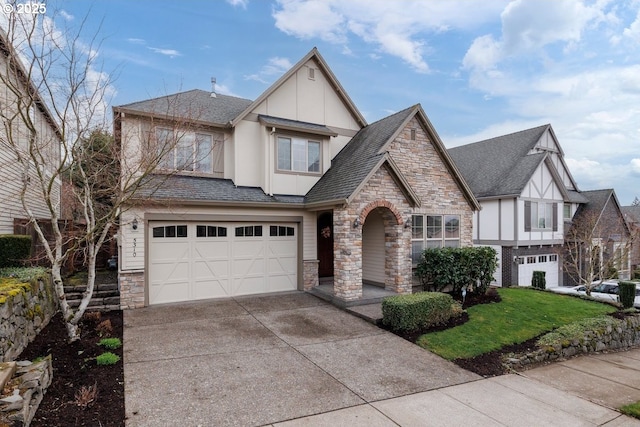 tudor-style house featuring stucco siding, stone siding, concrete driveway, an attached garage, and a shingled roof