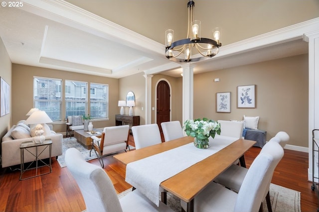 5310 NW Primino Ave, Portland, OR 97229 - dining area featuring wood finished floors, baseboards, ornate columns, a tray ceiling, and a chandelier