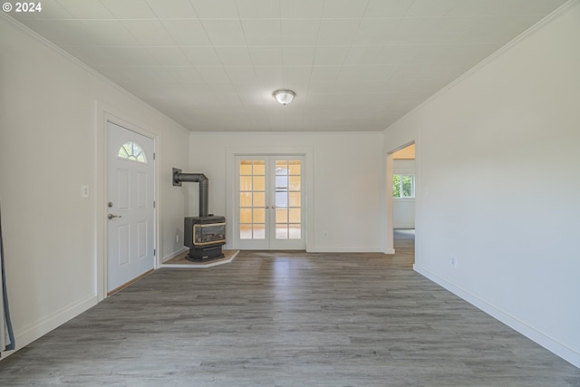 foyer entrance with a wood stove and light wood-type flooring