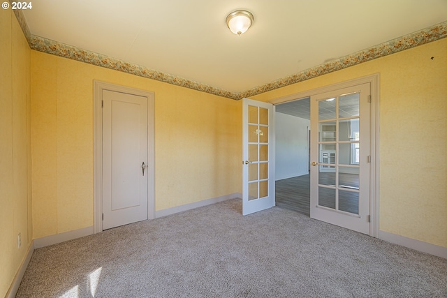 unfurnished room with french doors and carpet floors