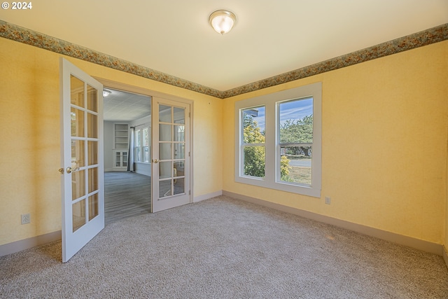 carpeted spare room with french doors