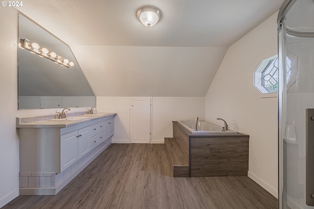 bathroom with hardwood / wood-style floors, vanity, and lofted ceiling